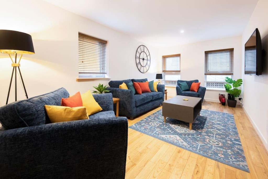 una sala de estar con 2 sofás azules y una mesa. en Modern City Centre Apartment in Inverness, en Inverness