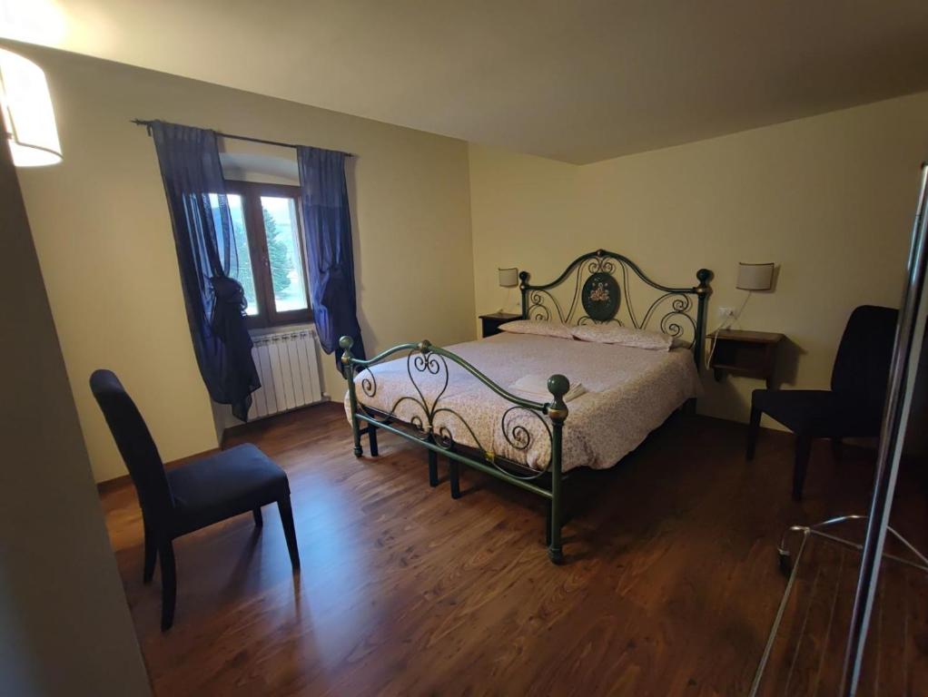 サンセポルクロにあるCasa Vacanze Nadiaのベッドルーム1室(ベッド1台、椅子、窓付)