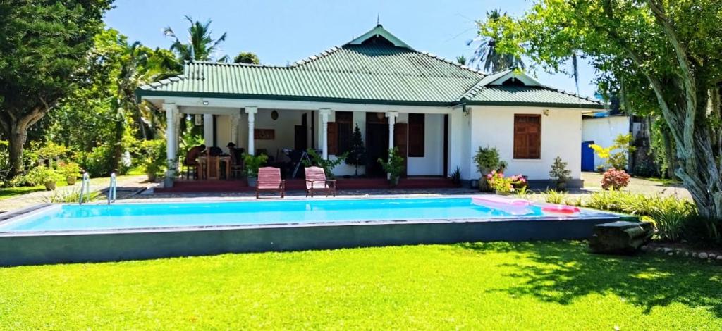 a house with a swimming pool in the yard at Tranquility guest house in Hikkaduwa
