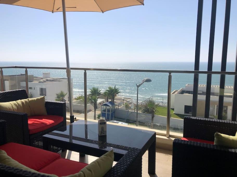 einen Balkon mit einem Tisch und Stühlen sowie Meerblick in der Unterkunft Superbe appartement vue sur mer in Salé