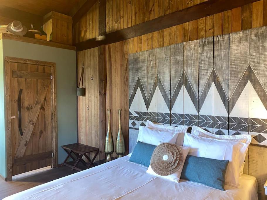 a bedroom with a white bed with a wooden wall at Pine Lodge - direct train to Porto in Valongo