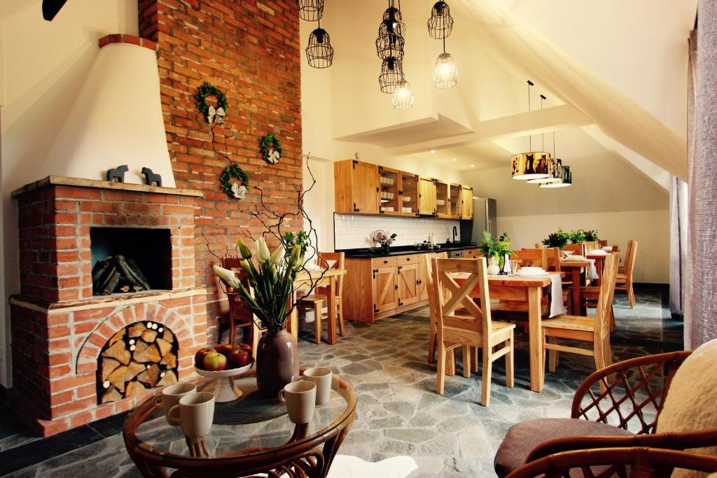 a kitchen and dining room with a brick fireplace at KOŃSKA GÓRKA Agroturystyka in Rabka-Zdrój