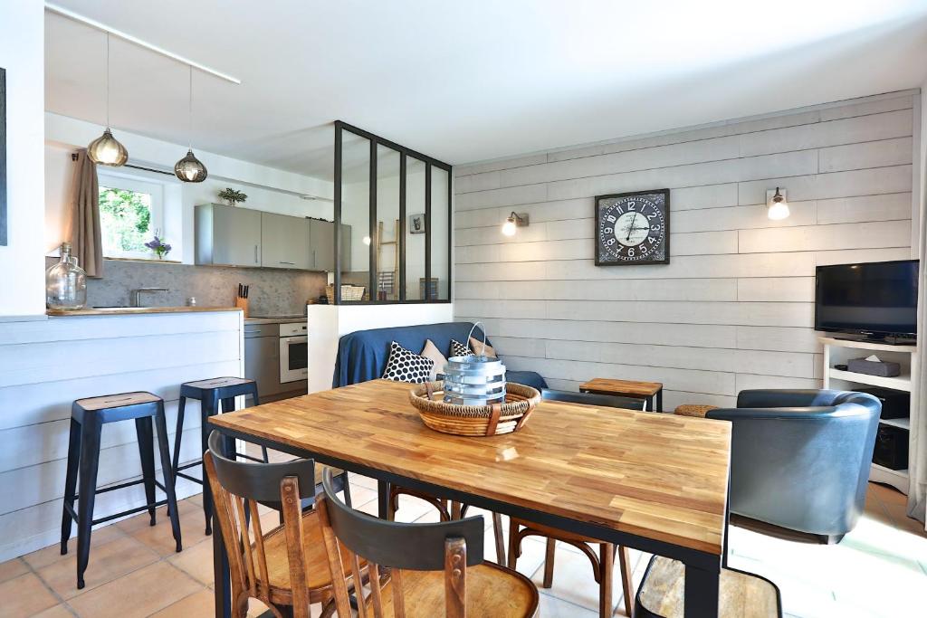 uma cozinha e sala de jantar com uma mesa de madeira e cadeiras em Le Bastidon de Guillemette em Gordes