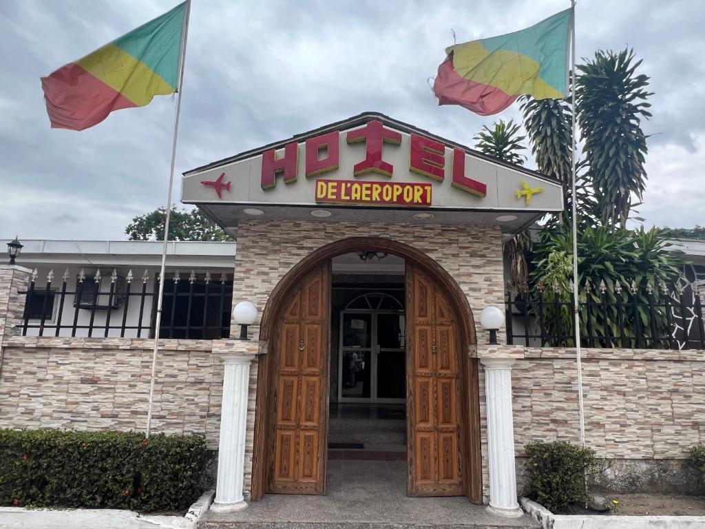 un restaurant avec deux drapeaux devant lui dans l'établissement Hotel de l'Aeroport, à Brazzaville