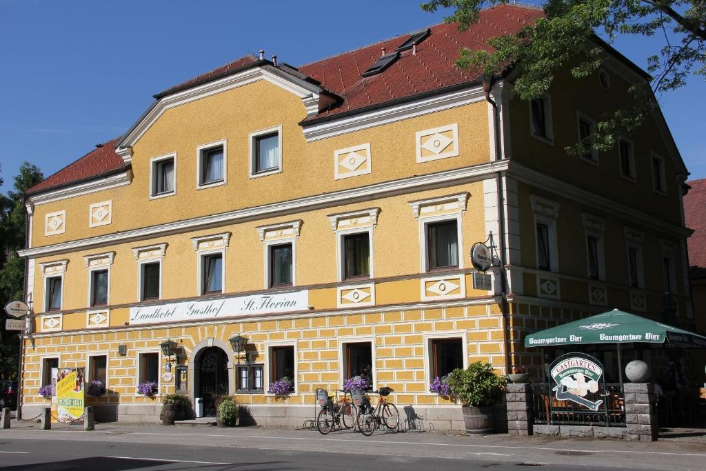 a yellow building with two bikes parked in front of it at Landhotel St. Florian in Sankt Florian am Inn