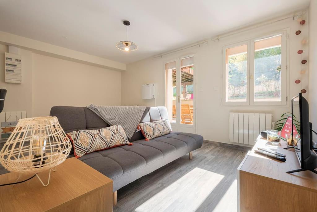 ein Wohnzimmer mit einem Sofa und einem Tisch in der Unterkunft L'Ainstant in Bellegarde-sur-Valserine