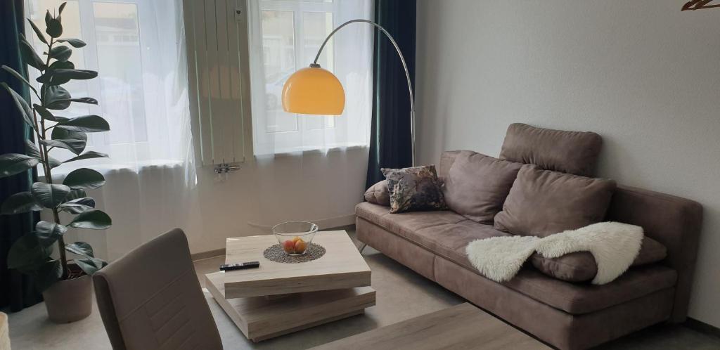 uma sala de estar com um sofá castanho e uma mesa em Möblierte Wohnung auf Zeit em Mühlhausen