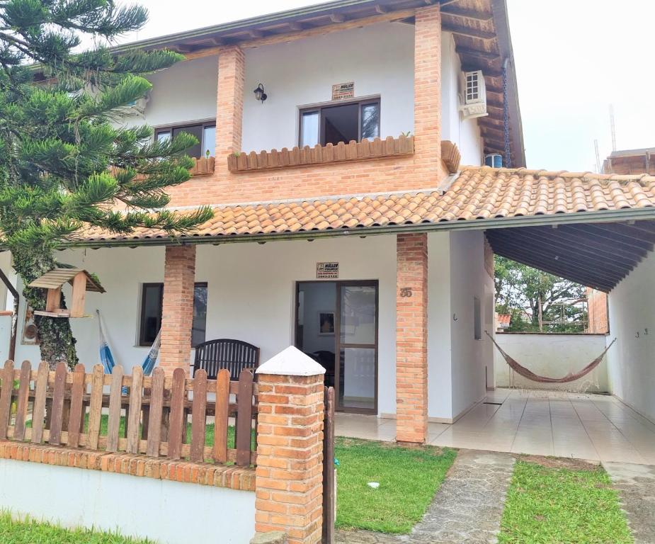 una casa con una recinzione di fronte di Casa Conforto! A sua casa de praia em Itapoá - SC a Itapoa