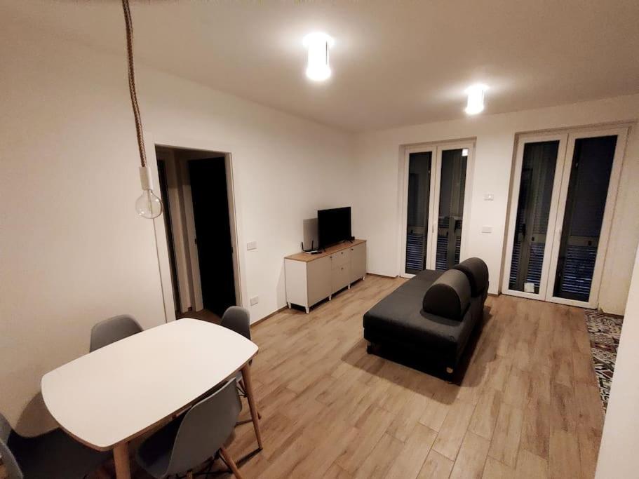 ein Wohnzimmer mit einem schwarzen Sofa und einem Tisch in der Unterkunft Apartment near to Como - Donkey's House in Tavernerio