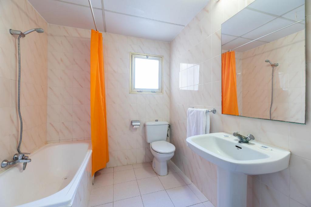 a bathroom with a sink and a tub and a toilet at Apartamento bonito en Salou con piscina in Salou