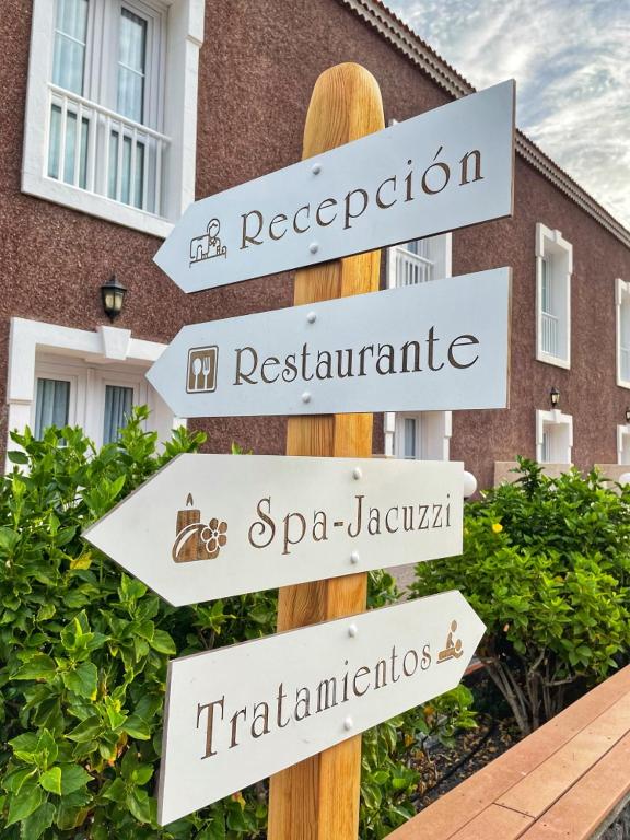 a pole with street signs in front of a building at Balneario Pozo de la Salud in Sabinosa
