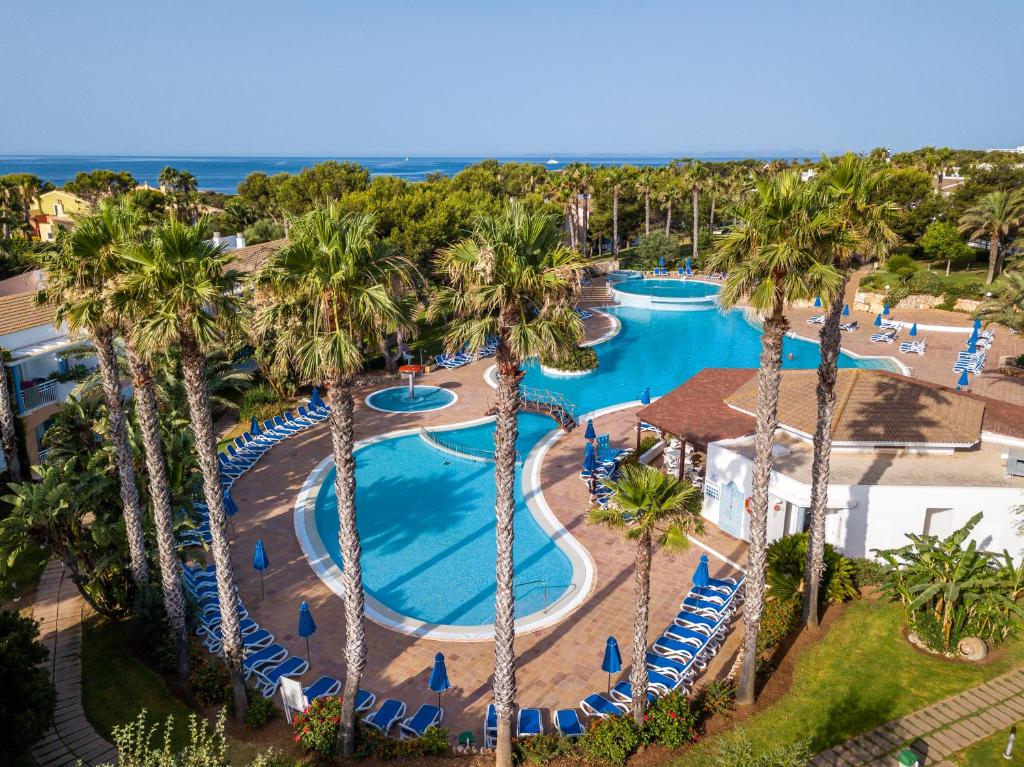 uma vista sobre uma piscina de resort com palmeiras em Sagitario Princesa Playa em Son Xoriguer