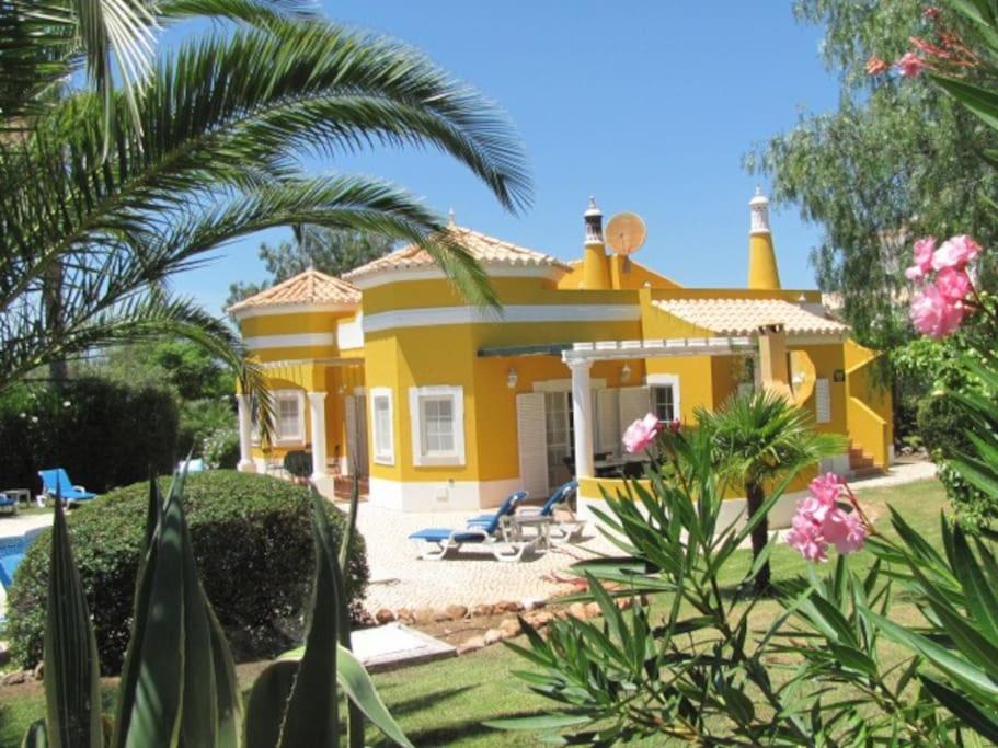 a yellow house with a palm tree in front of it at Vivenda Vista Verde in Portimão