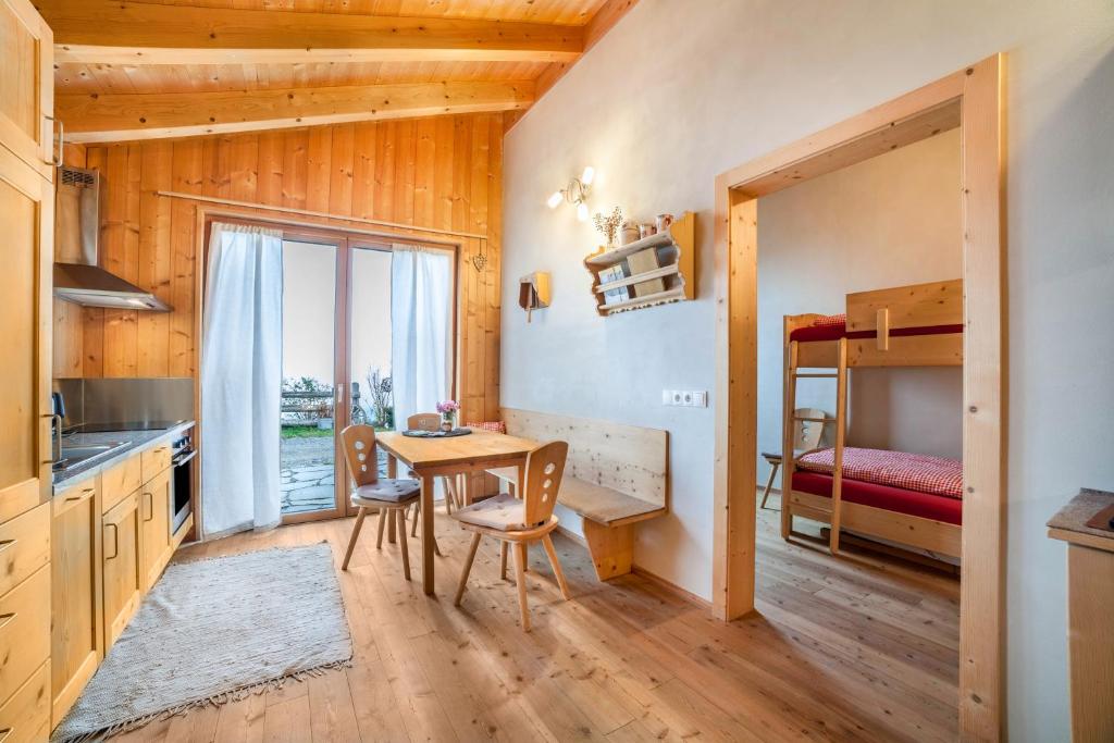 蘇魯德爾諾的住宿－Grushof App Köpfl，厨房以及带桌子和双层床的用餐室。