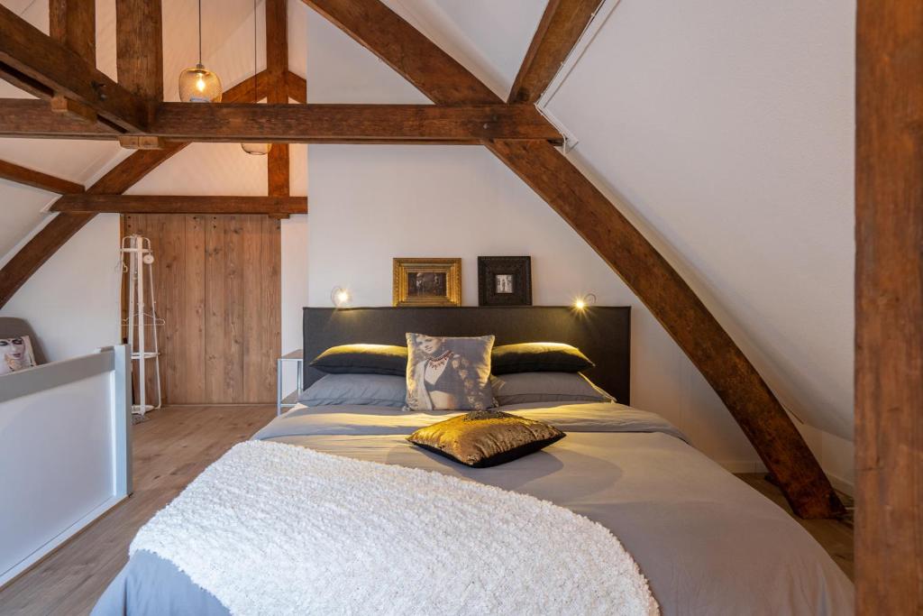 ein Schlafzimmer mit einem großen Bett im Dachgeschoss in der Unterkunft B&B aan de Koningsmuur in Dieren