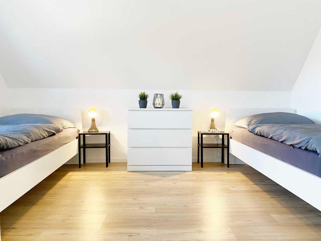 two beds in a room with two lamps on tables at Spacious & Chic Apartment with Balcony in Ibbenbüren