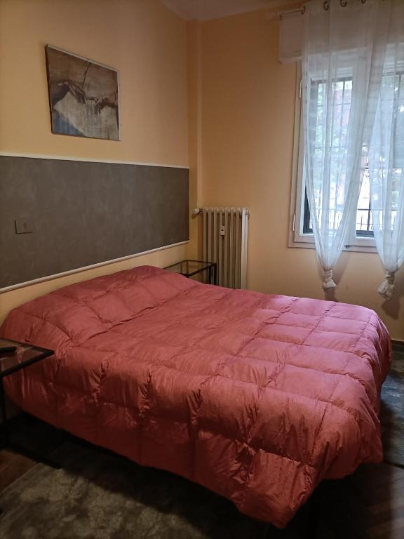 a bedroom with a large bed with a red blanket at La casa di Laura in Bologna