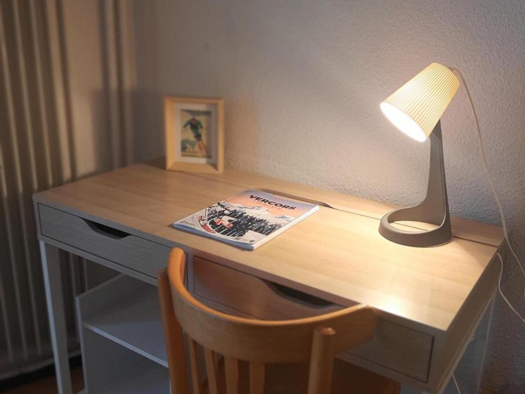 a desk with a lamp and a book on it at Appartement Villard-de-Lans, 2 pièces, 6 personnes - FR-1-515-3 in Villard-de-Lans