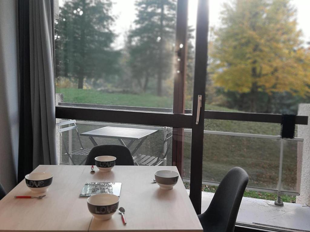 una mesa con dos tazas junto a una ventana en Studio Villard-de-Lans, 1 pièce, 4 personnes - FR-1-515-110, en Villard-de-Lans