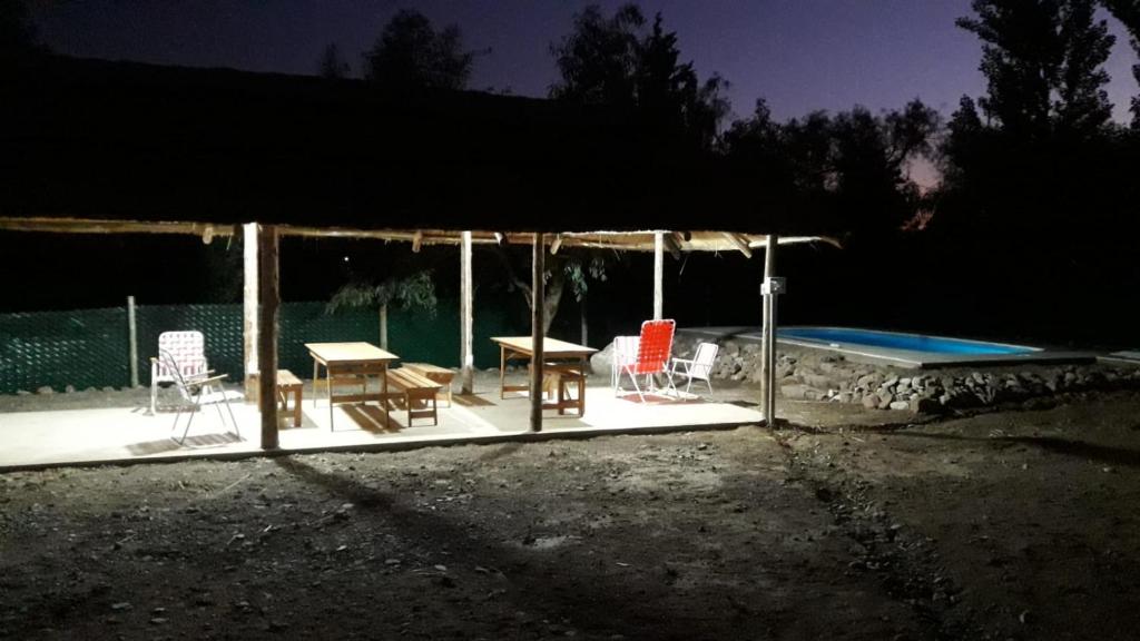 un patio con mesa y sillas junto a una piscina en Posta Malbec en Las Compuertas