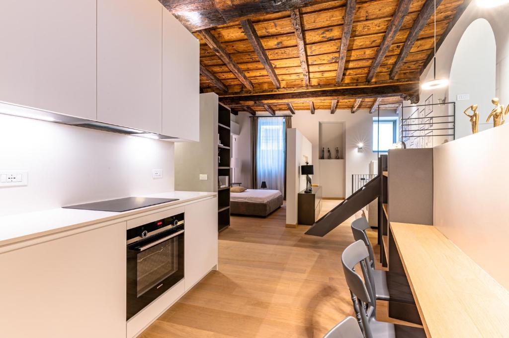 een keuken met witte kasten en een houten plafond bij BnButler - Bergamo Città Alta - Appartamento di Charme in Bergamo