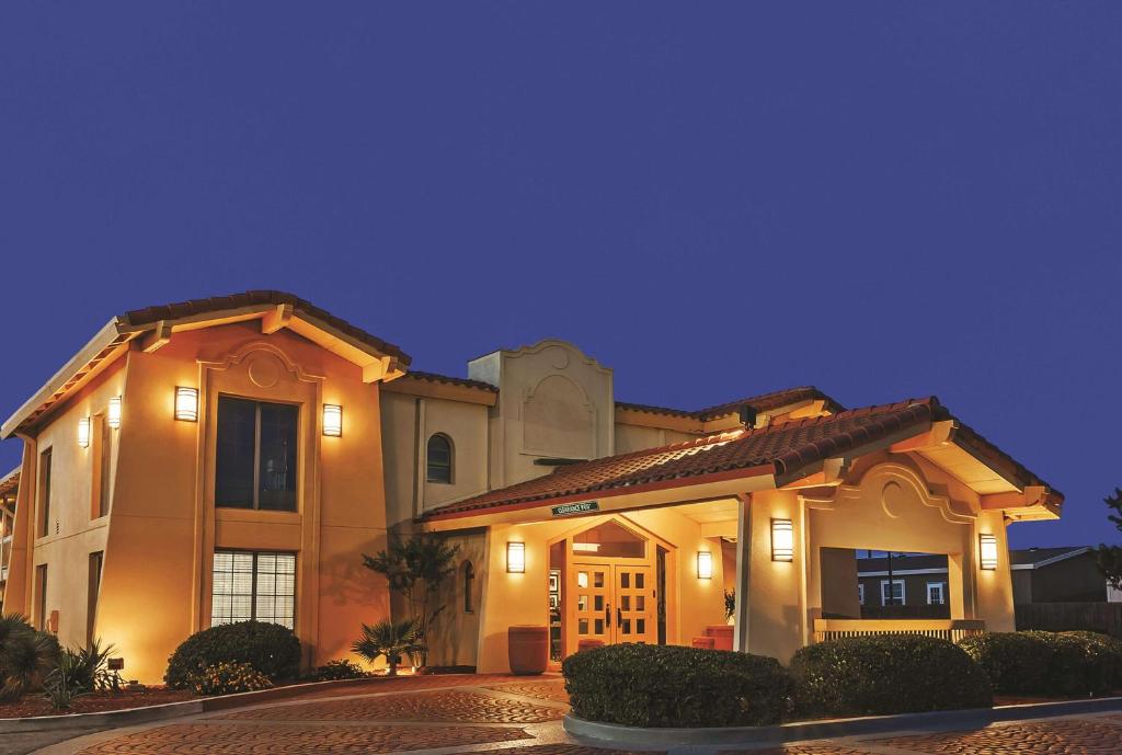 a large house with lights on the front of it at La Quinta Inn by Wyndham Midland in Midland