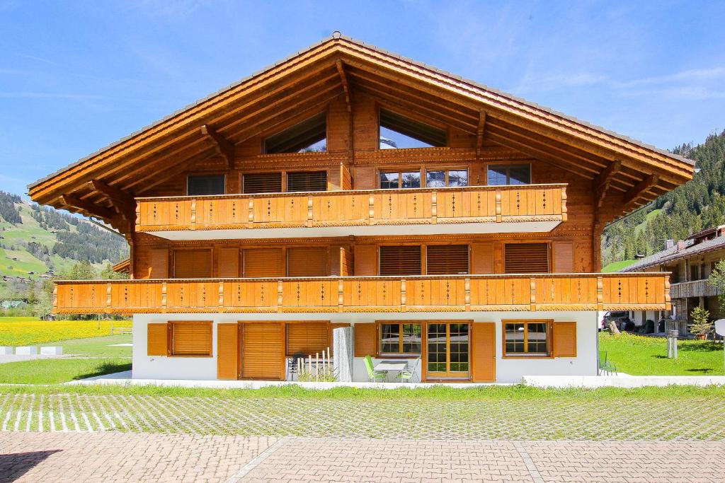 a large wooden building with a large balcony at Ferienwohnung Bärtschi in Lenk