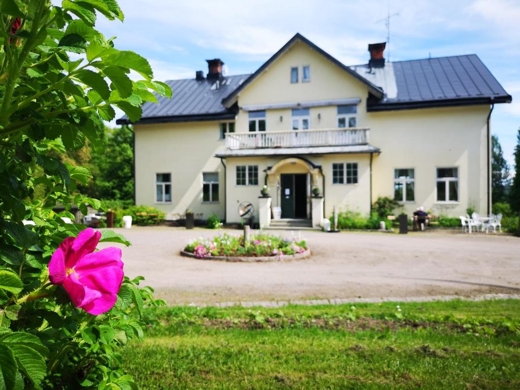 una casa con una flor rosa delante de ella en Disponentparken Café och Bed & Breakfast, en Grängesberg