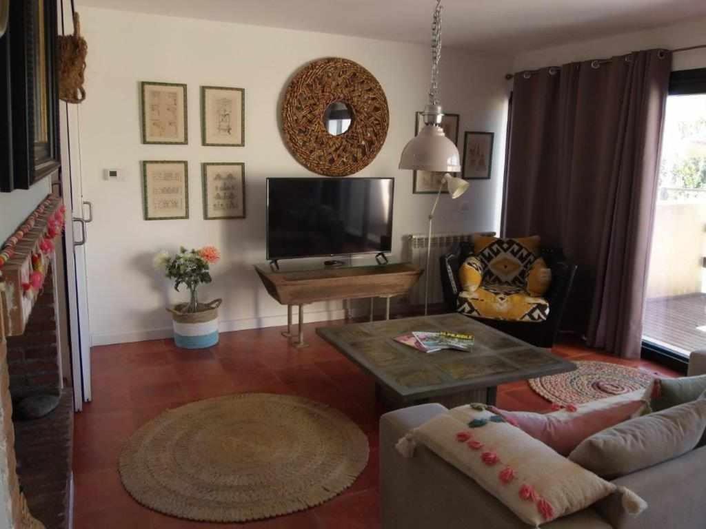 salon z kanapą i telewizorem w obiekcie Casa Iona chalet adosado con vistas a la montaña w mieście Navarredonda de Gredos