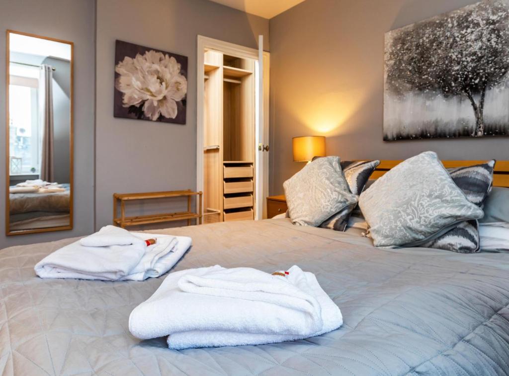 een slaapkamer met een bed met handdoeken erop bij Modern Aberdeen City apartment free parking in Aberdeen