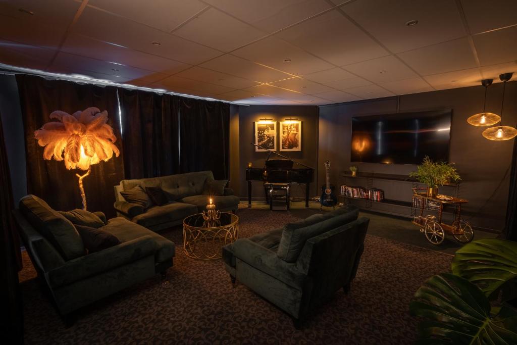 a living room with couches and a piano at Hotell Entré Norr in Umeå