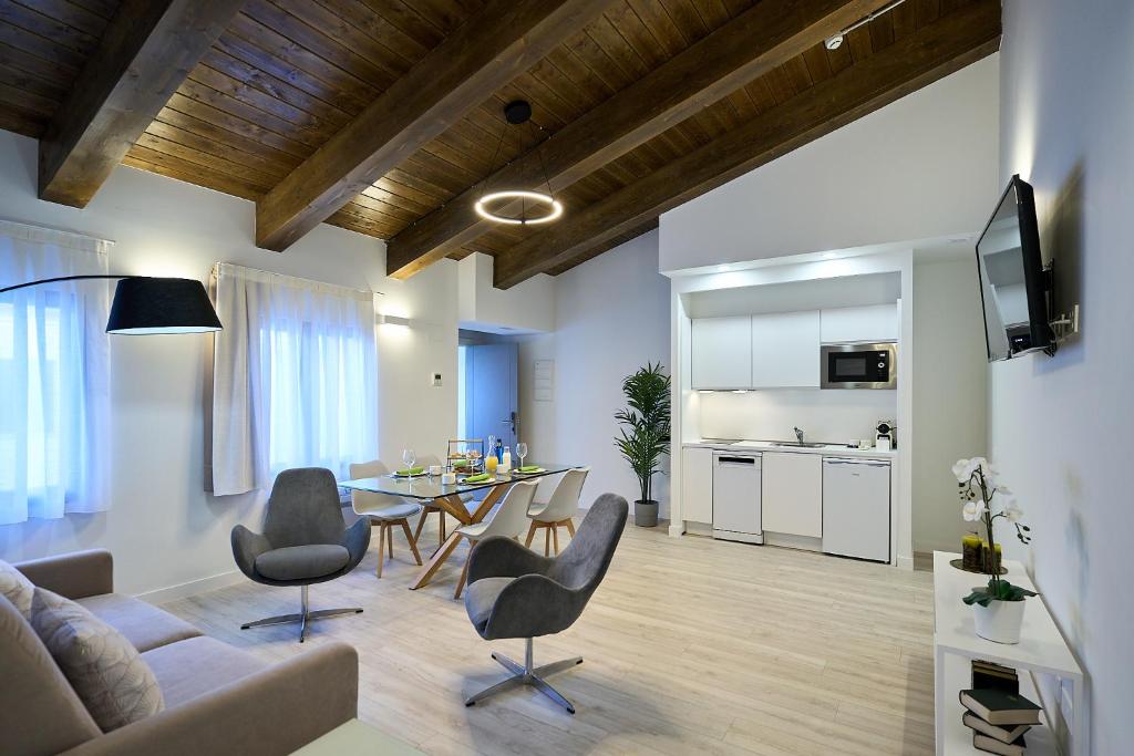 a living room with a couch and a table and chairs at Inés Luna Suites in Salamanca