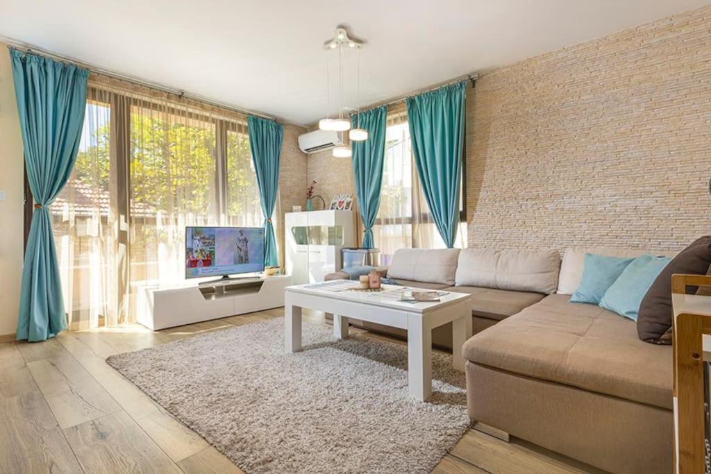 a living room with a couch and a table at Brand new Central apartment, 10 minutes to Center in Plovdiv