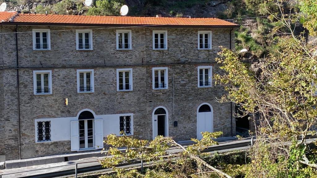 a large brick building with white windows and trees at B&B Gronda Via Vandelli in Massa