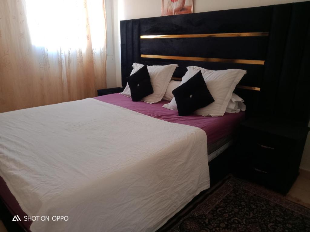 a bedroom with a large bed with white sheets and pillows at Les jardaine d'ifrane in Ifrane