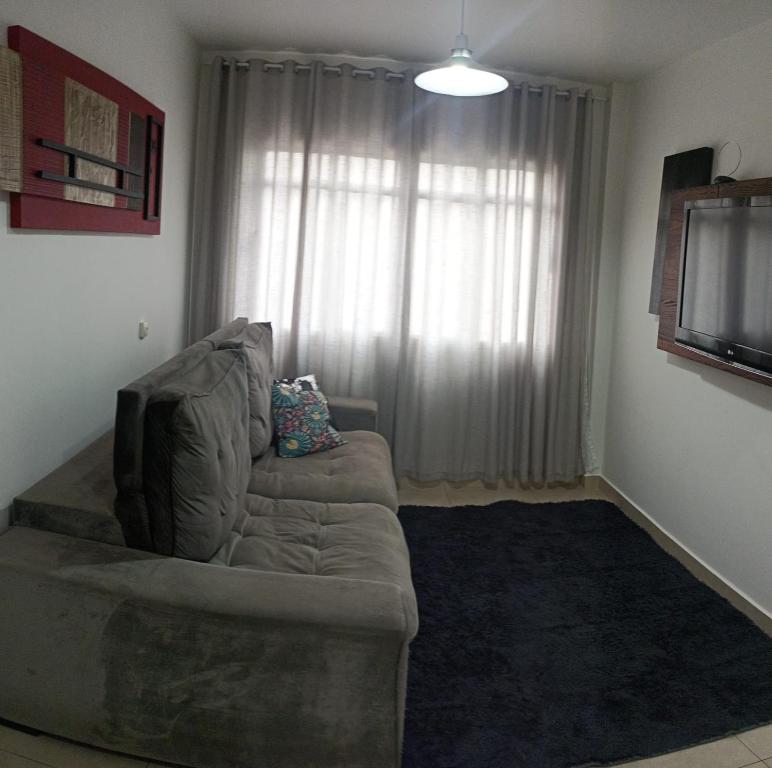 a living room with a couch in front of a window at Apartamento amplo e acolhedor, garagem incluída. in Foz do Iguaçu