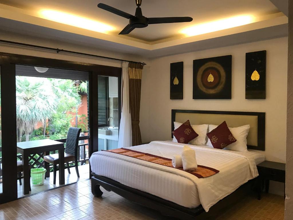a bedroom with a bed with a ceiling fan at Arina Boutique Residence in Chaweng