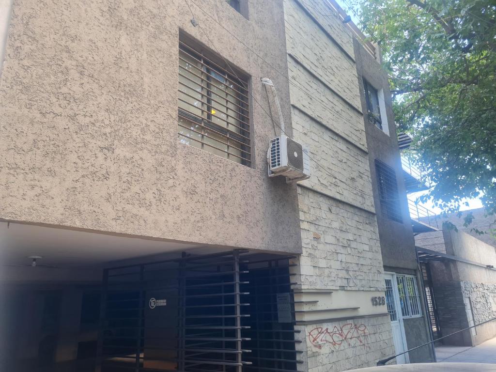 un edificio con ventana y puerta con ventilador en Departamento Salta en Mendoza