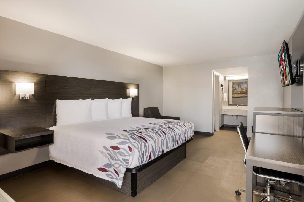 ein Hotelzimmer mit einem großen Bett und einem Bad in der Unterkunft Red Roof Inn Alexandria, LA in Alexandria