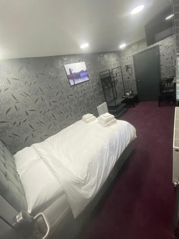 Un dormitorio con una cama blanca con una foto en la pared en Mannbuilding en Londres