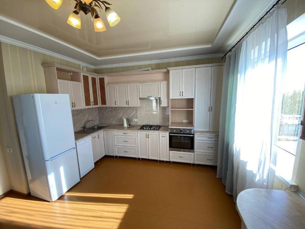 een keuken met witte kasten en een witte koelkast bij Gagarina Naberegnaya in Dnipro