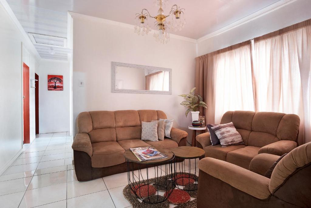 a living room with a couch and a table at 25 Jacaranda Lodge & Backpackers in Pinetown