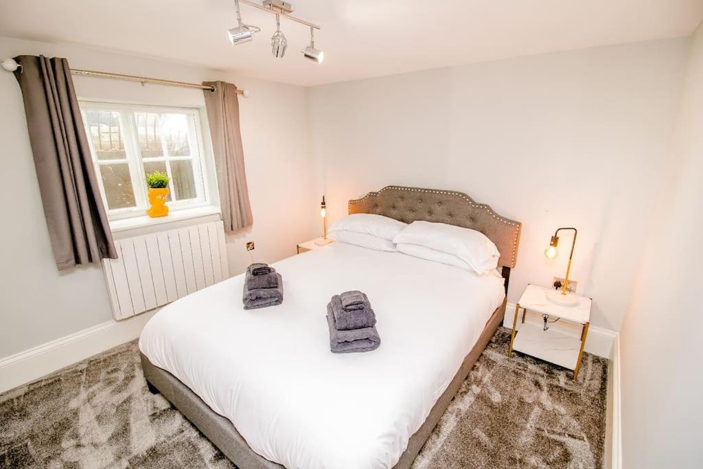 - une chambre dotée d'un lit blanc avec deux sacs dans l'établissement Spacious 2 bed city centre apartment with parking, à Norwich