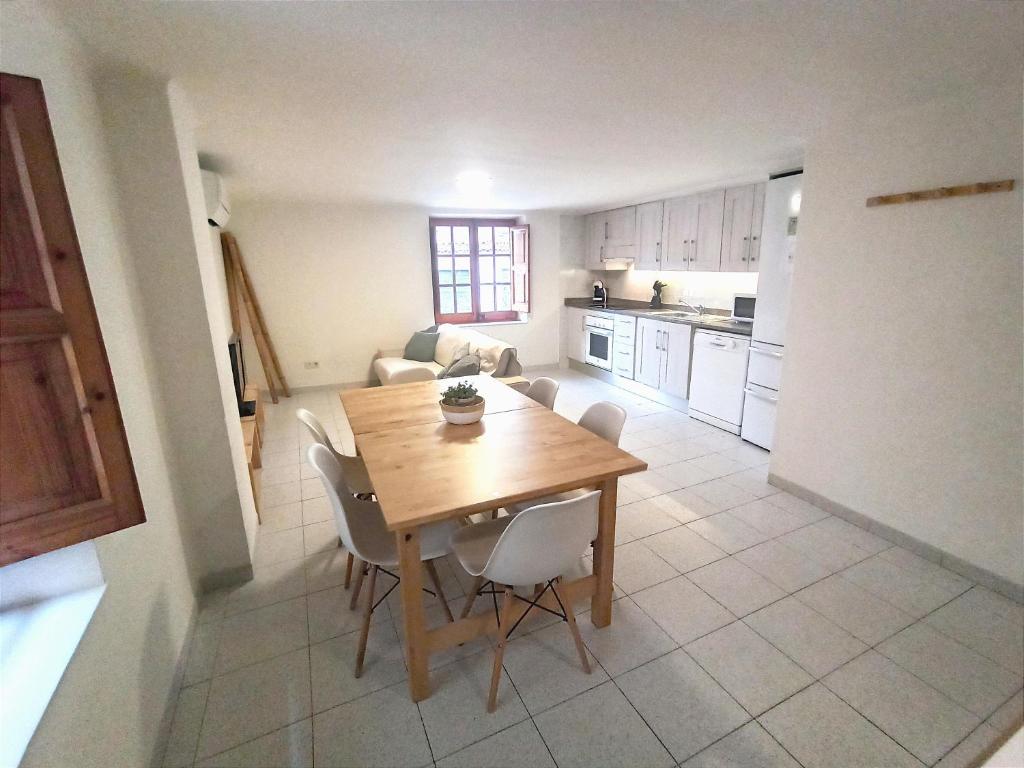 una cucina e una sala da pranzo con tavolo e sedie in legno di Ca la iaia - Turisme familiar ad Amer