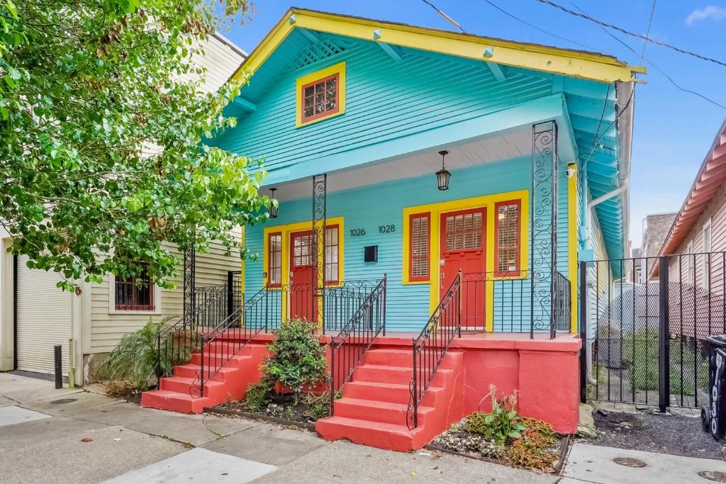 una casa colorida con puertas rojas en una calle en Have Your Cake, en Nueva Orleans