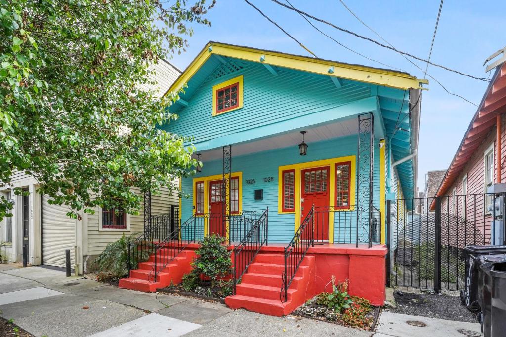 a colorful house with red doors on a street at Eat Your Cake Too in New Orleans