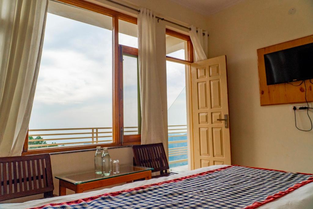 a bedroom with a bed and a view of the ocean at Jot Eco Boutique Stays in Dharamshala