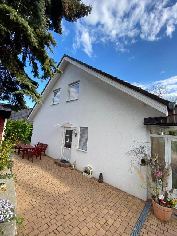 een wit huis met een patio en een tafel bij Ferienwohnung Pupavac in Bad Frankenhausen