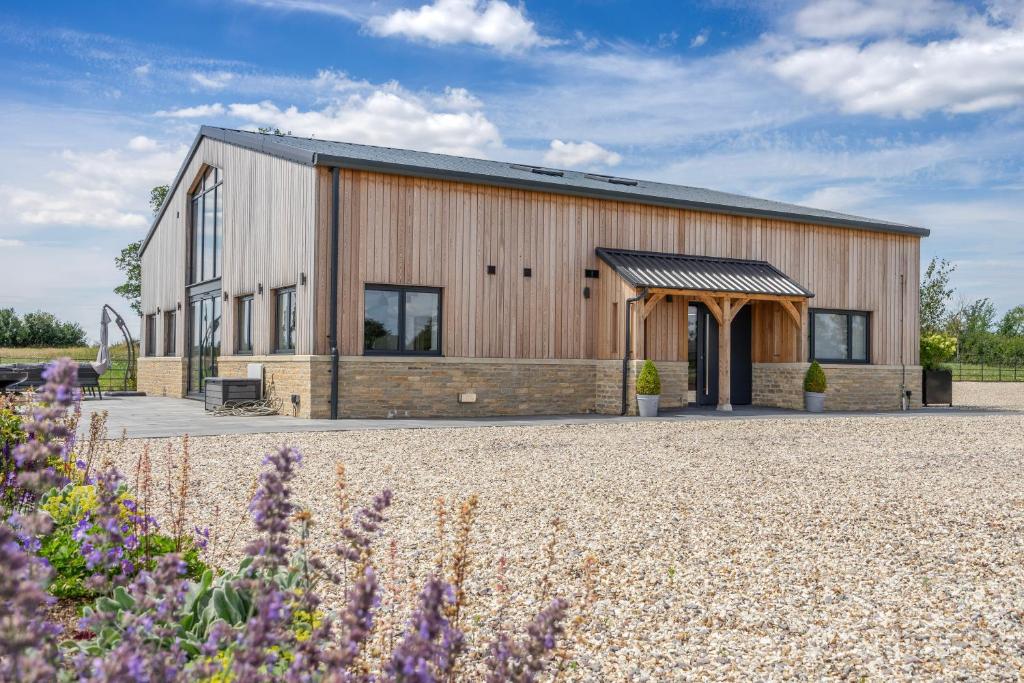 a barn style building with a gravel driveway at The Grove - Converted Cattle Barn in Malmesbury