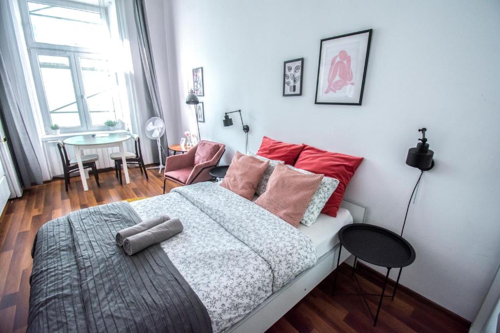 um quarto com uma cama com almofadas vermelhas e uma mesa em LION apartments - LaBA em Cracóvia